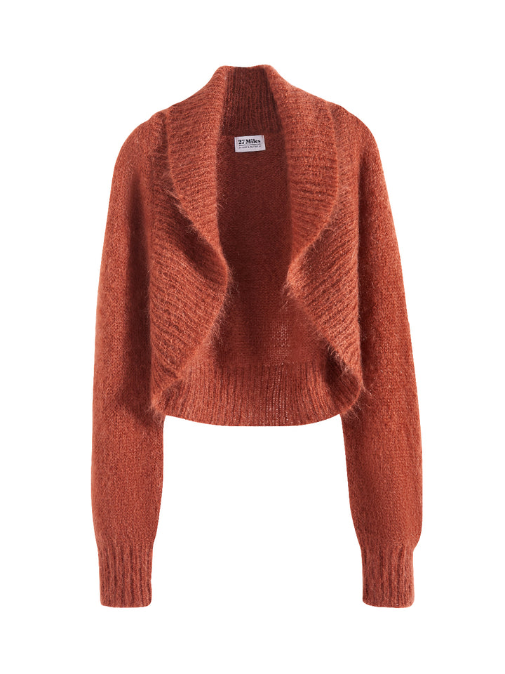 Flatlay photo of Odi in ginger orange. The sweater is relaxed and made of 70% mohair and 30% wool. The sweater is a shrug with a ribbed-knit shawl lapel.