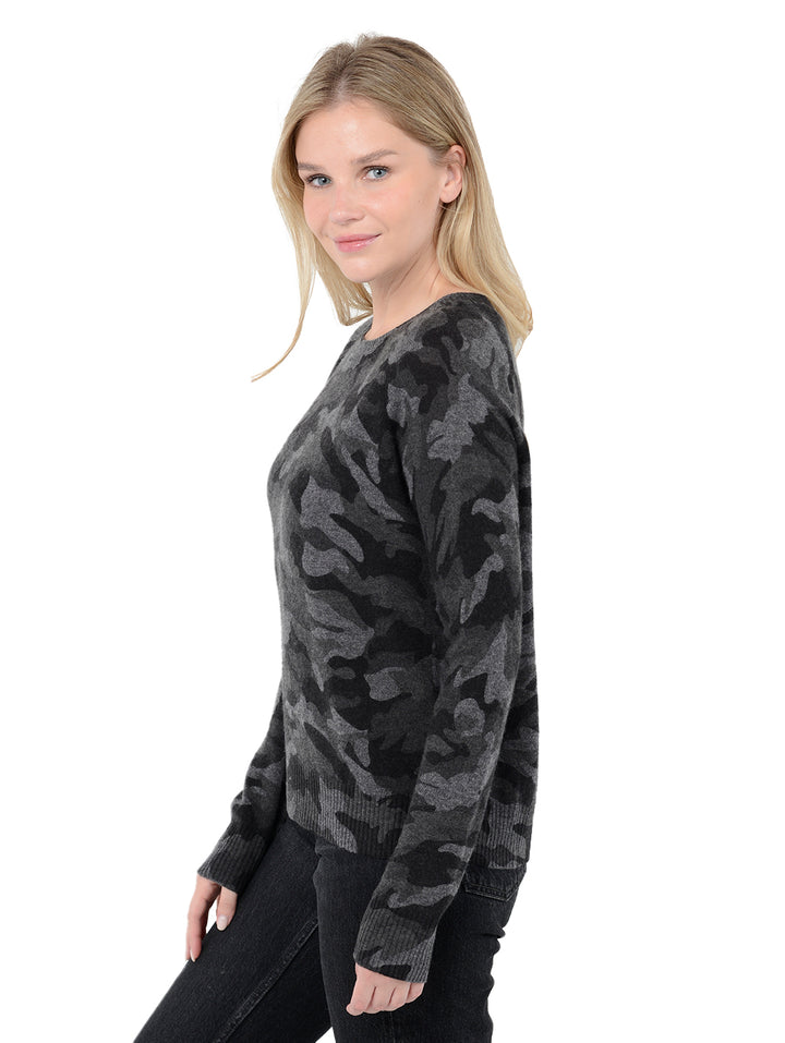 Side view of model wearing Tasha in black. The sweater is straight fit and made of cashmere. The pullover has a all-over camouflage print