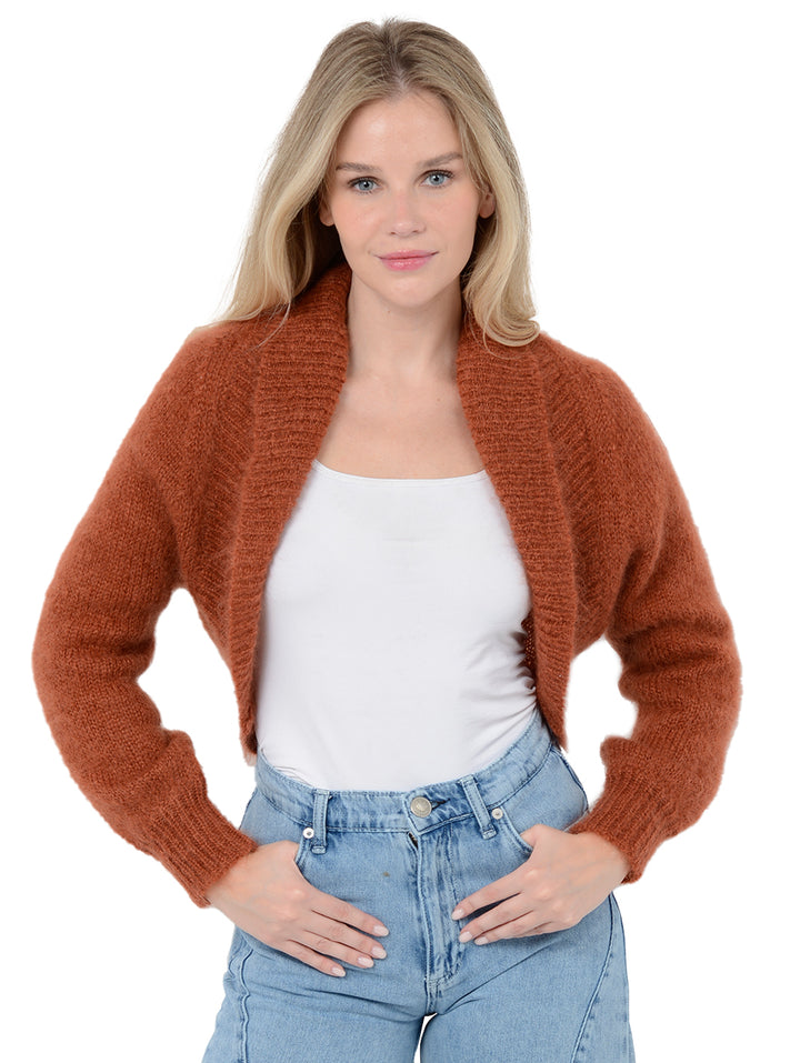 Front facing shot of model wearing Odi in ginger orange. The sweater is relaxed and made of mohair and wool. The sweater is a shrug with a ribbed-knit shawl lapel.