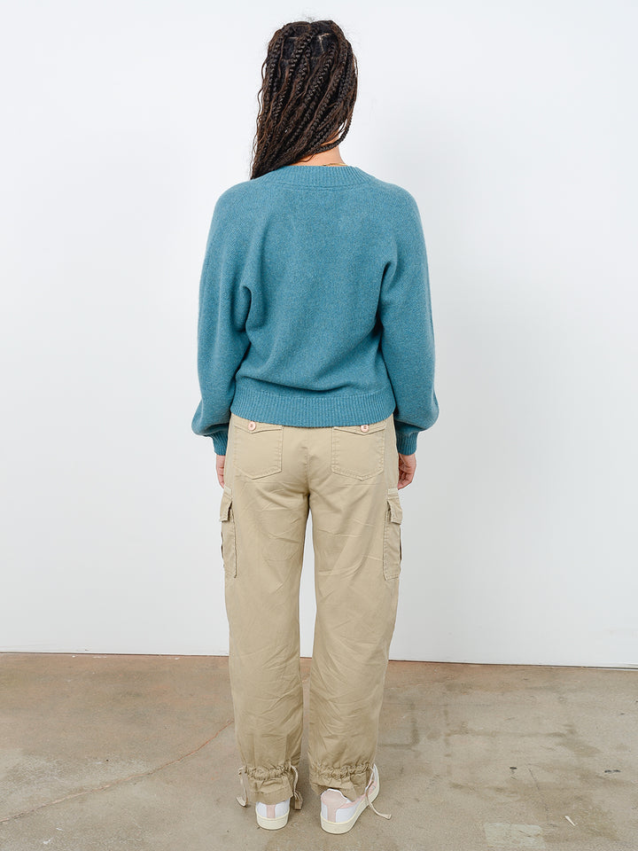 Back facing shot of model wearing Binney in fern green. The sweater is straight fit and made of cashmere and recycled cashmere.
