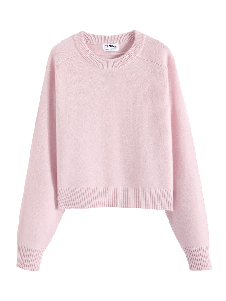 Flatlay photo of Iliana in petal pink. The sweater is oversized and cropped and made of 100% cashmere. The sweater also sports a saddle sleeve and crewneck.