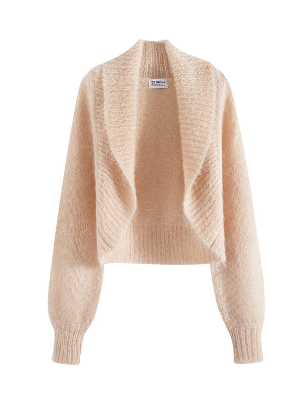 Flatlay photo of Odi in latte cream. The sweater is relaxed and made of 70% mohair and 30% wool. The sweater is a shrug with a ribbed-knit shawl lapel.