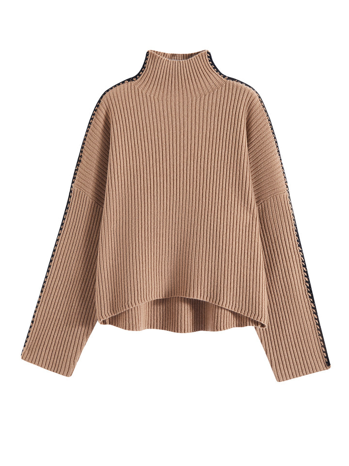 Flatlay photo of Marullo in camel brown. The sweater is oversized and made of wool and cashmere. The sweater is a mock neck with crochet-like embroidery along the sleeves and shoulders.