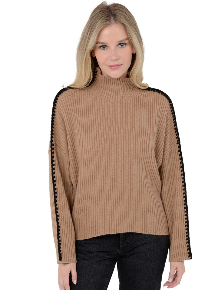Front facing shot of model wearing Marullo in camel brown. The sweater is oversized and made of wool and cashmere. The sweater is a mock neck with crochet-like embroidery along the sleeves and shoulders.
