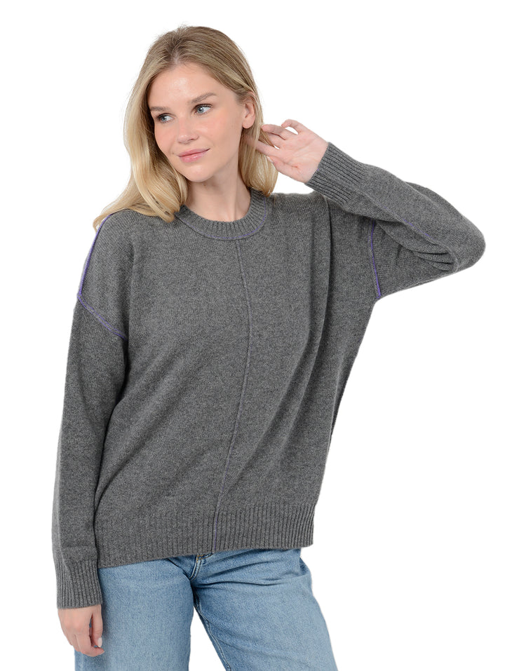 Alternate front facing shot of model wearing Venise in gravel grey. The sweater is oversized and made of cashmere and recycled cashmere. The sweater is a crewneck pullover with decorative reversed seams.