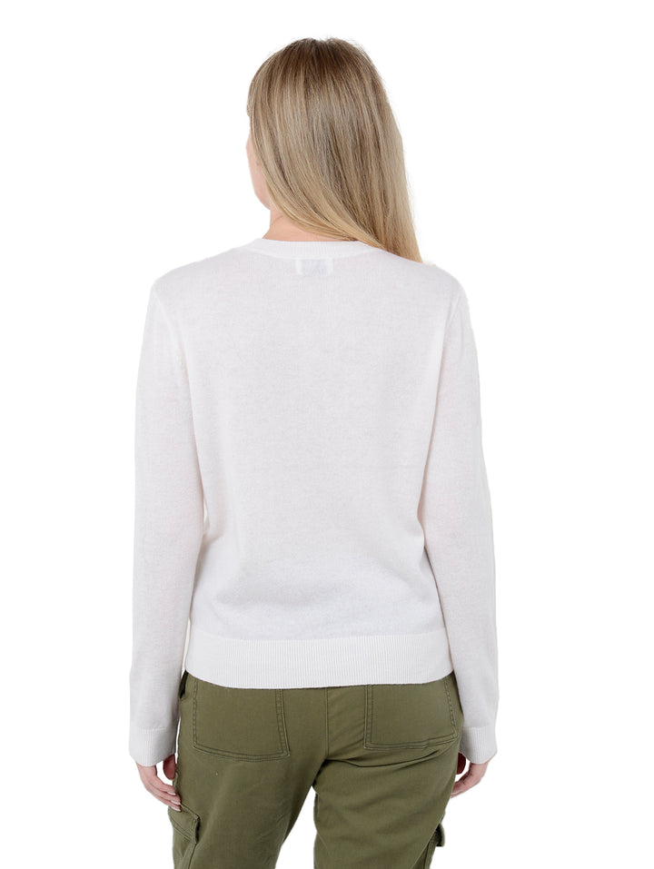 Back facing shot of model wearing Alston in chalk white. The sweater is straight fit and made of cashmere, wool, and silk. The sweater is a crewneck pullover and has a large retro flower intarsia artwork.