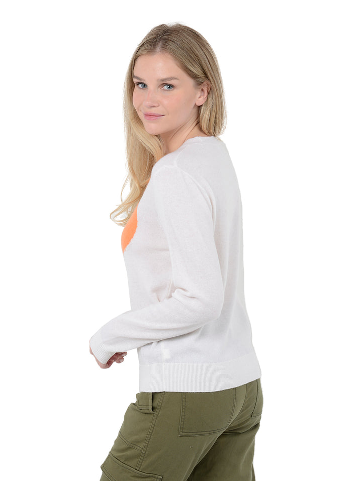 3/4 back facing shot of model wearing Alston in chalk white. The sweater is straight fit and made of cashmere, wool, and silk. The sweater is a crewneck pullover and has a large retro flower intarsia artwork.
