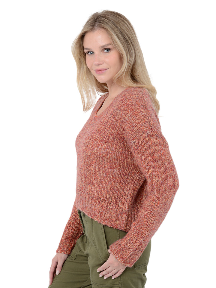 3/4 front view of model wearing Gaetana in prairie. The sweater is oversized and cropped and made of cashmere, wool, nylon and silk. The color of the sweater comes from marled yarns and the sweater has a high-low hem.