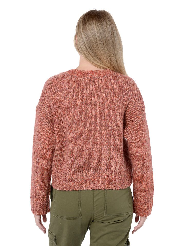 Back view of model wearing Gaetana in prairie. The sweater is oversized and cropped and made of cashmere, wool, nylon and silk. The color of the sweater comes from marled yarns and the sweater has a high-low hem.