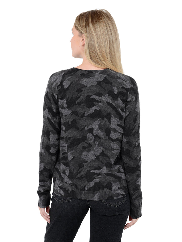 Back facing shot of model wearing Tasha in black. The sweater is straight fit and made of cashmere. The pullover has a all-over camouflage print