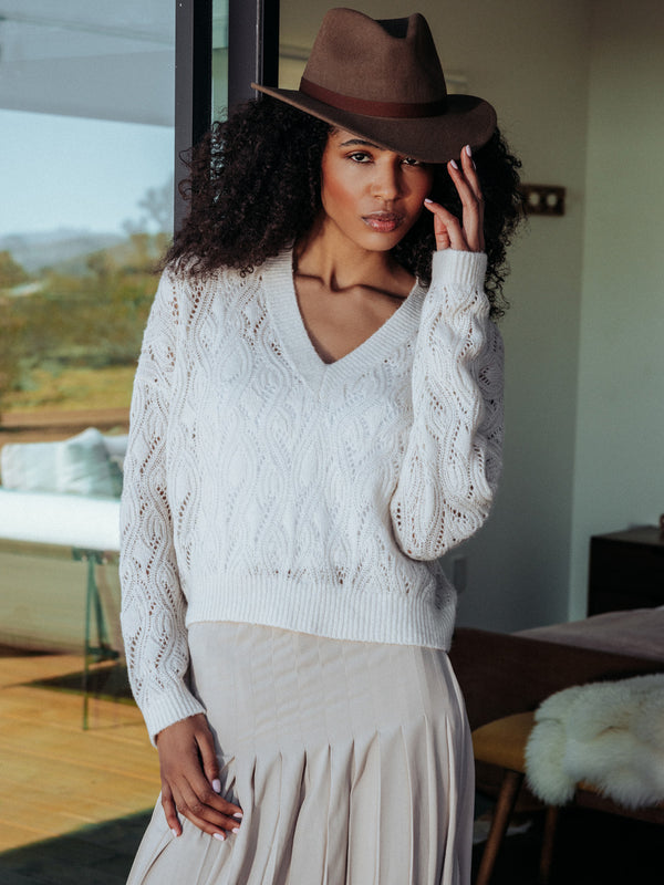 Editorial shot of model wearing Mckinnon in a vacation cabin. Sweater is relaxed and made of cashmere and silk.