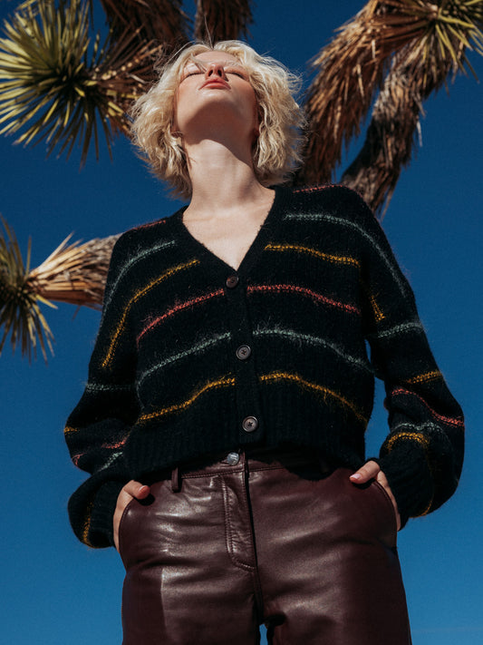 Low angle editorial shot of model wearing Micaela cardigan contrasted against the desert sky.