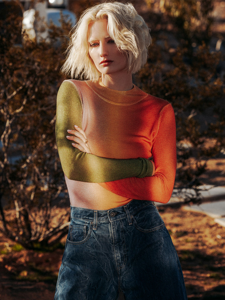 Editorial shot of model wearing Zorina in a dry forest. Sweater is fitted and made of 100% cashmere.