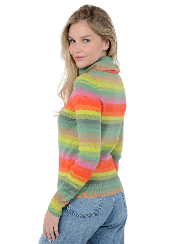 Side view of model wearing Carina in jade rainbow stripes. The sweater is straight fit and made of 100% cashmere. The sweater is a striped turtleneck.