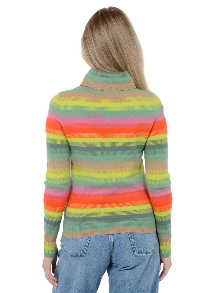 Back facing shot of model wearing Carina in jade rainbow stripes. The sweater is straight fit and made of 100% cashmere. The sweater is a striped turtleneck.