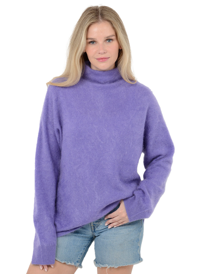 Front facing shot of model wearing Morgan in violet purple. The sweater is oversized and made of 100% cashmere. The sweater is a fuzzy turtleneck pullover.