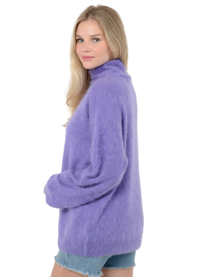 Side view of model wearing Morgan in violet purple. The sweater is oversized and made of 100% cashmere. The sweater is a fuzzy turtleneck pullover.