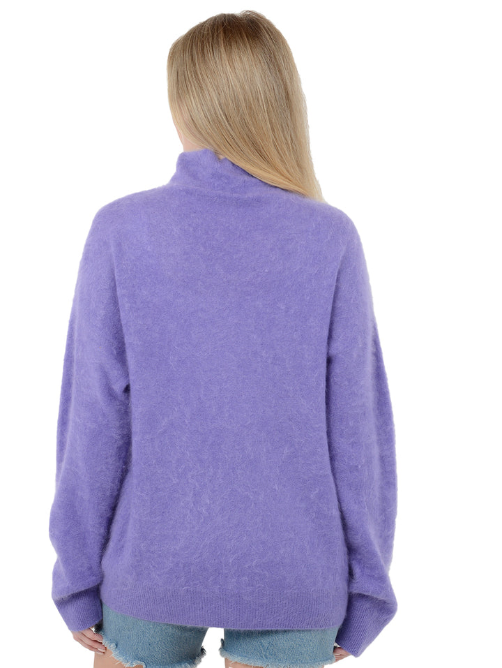 Back facing shot of model wearing Morgan in violet purple. The sweater is oversized and made of 100% cashmere. The sweater is a fuzzy turtleneck pullover.