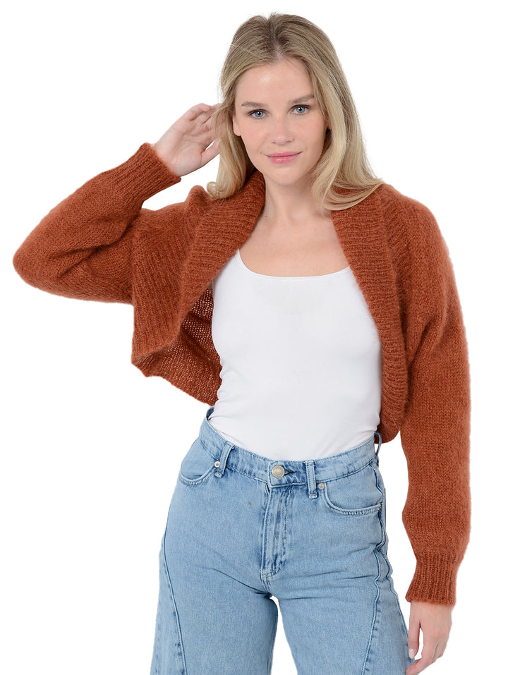 Alternate front facing shot of model wearing Odi in ginger orange. The sweater is relaxed and made of mohair and wool. The model has one arm up with her hand in her hair.