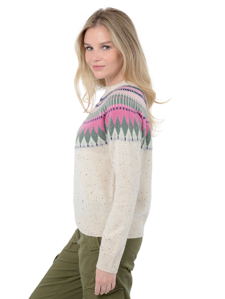 Side view shot of model wearing Salena in Pebble Cream. The sweater is relaxed and made of 100% cashmere. The sweater also sports a fairisle knit design across the chest and neck.