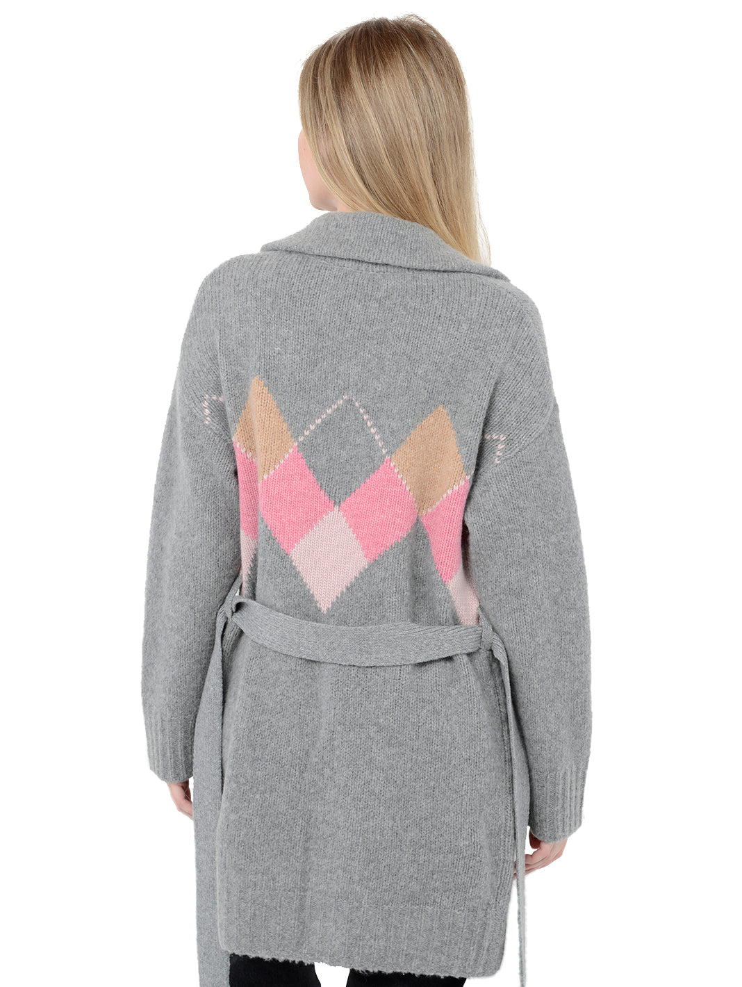 Back facing shot of model wearing Tuscany in flannel grey. The sweater is long and oversized and made of wool, cashmere, and nylon. The sweater features a tie around the waist and patch pockets.