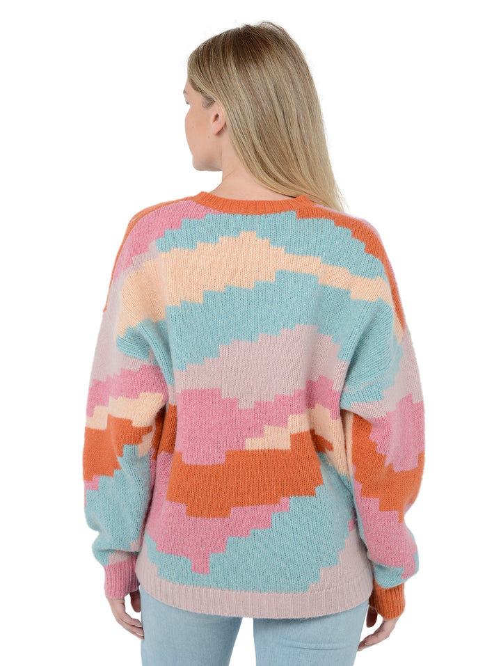Back facing shot of model wearing Ersa in multi color. The sweater is oversized and made of merino wool. The sweater features a blocky pattern made of a blend of wool, cashmere, and nylon.