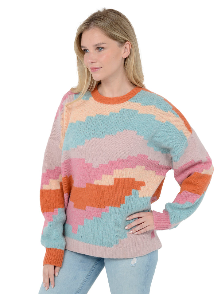 3/4 view shot of model wearing Ersa in multi color. The sweater is oversized and made of merino wool. The sweater features a blocky pattern made of a blend of wool, cashmere, and nylon.