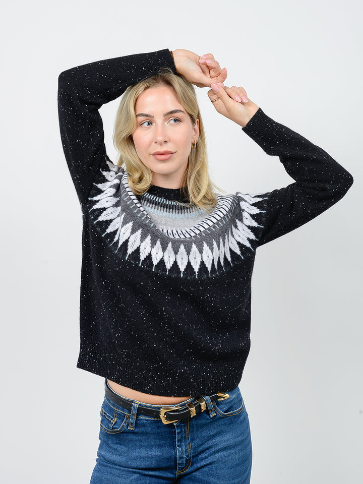 Front facing shot of model wearing Salena in tinder black. The sweater is relaxed and made of 100% cashmere. The sweater also sports a fairisle knit design across the chest and neck.