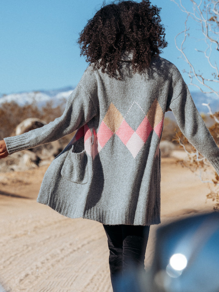 Editorial shot of model walking away wearing tuscany. The angel shows the argyle pattern on the back of the sweater.